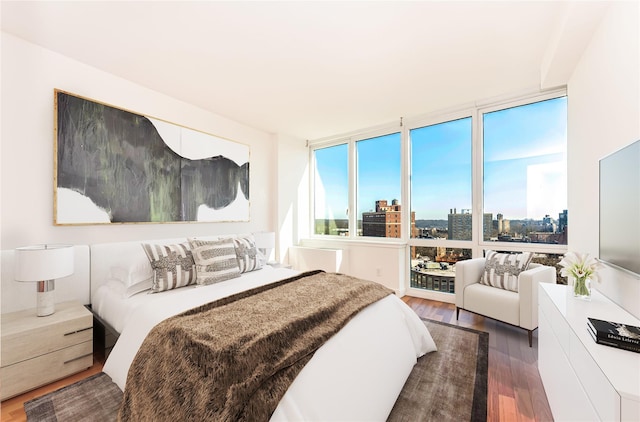 bedroom with dark wood-style floors and a wall of windows