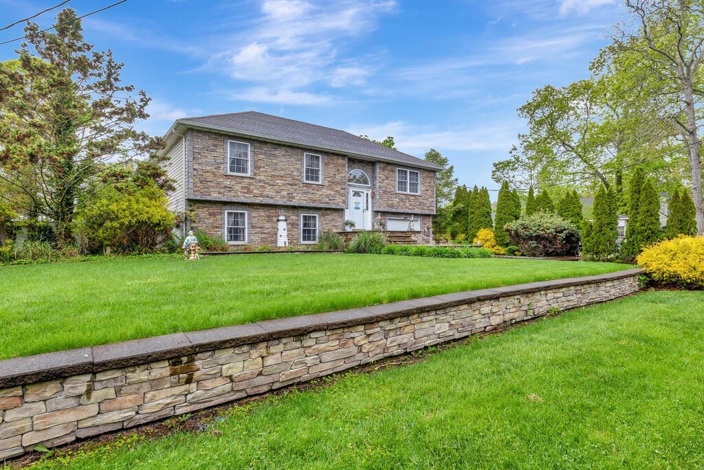 102 Dahlia Dr, Mastic Beach, NY 11951 - raised ranch with stone siding and a front lawn
