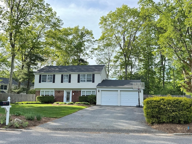 colonial inspired home with asphalt driveway, a garage, and brick siding