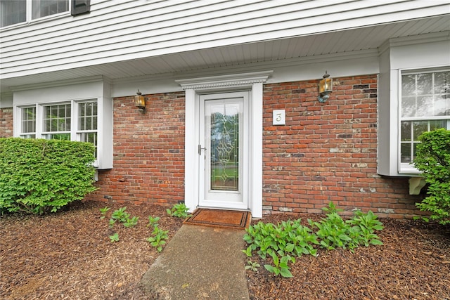 doorway to property with brick siding