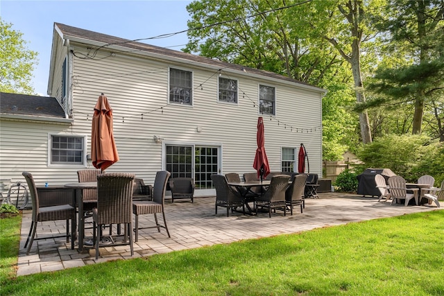 rear view of house with a patio and a lawn