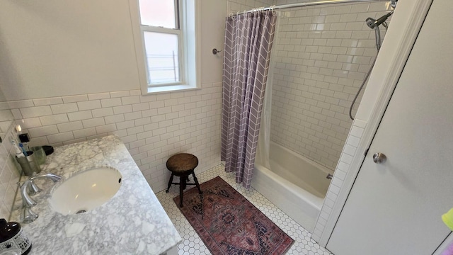 full bath with tile walls, a sink, shower / tub combo, tile patterned flooring, and wainscoting
