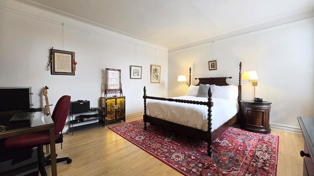 bedroom with ornamental molding, light wood-style flooring, a desk, and baseboards