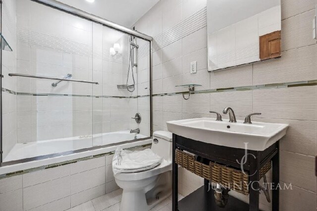 150-38 Union Tpke Unit 4K, Flushing, NY 11367 - full bath with tile walls, tiled shower / bath combo, toilet, a sink, and tile patterned floors