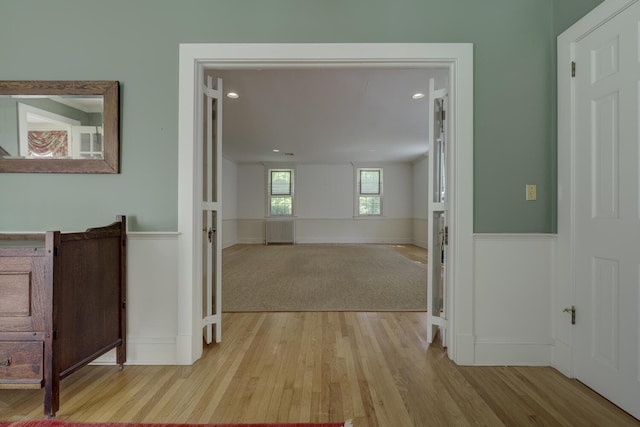 hall with wood finished floors, wainscoting, and recessed lighting