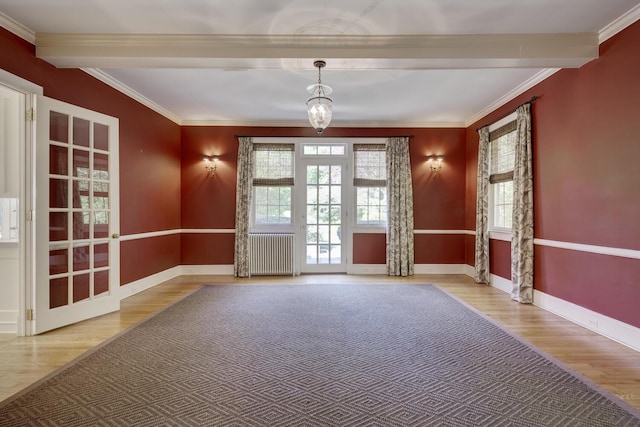 spare room featuring radiator heating unit, wood finished floors, beamed ceiling, baseboards, and ornamental molding