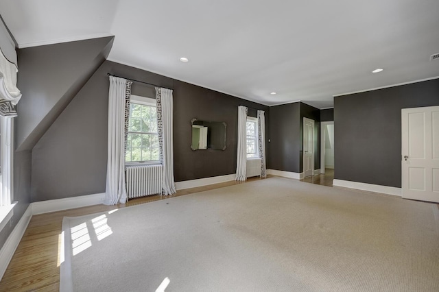 bonus room with baseboards, healthy amount of natural light, radiator, recessed lighting, and wood finished floors