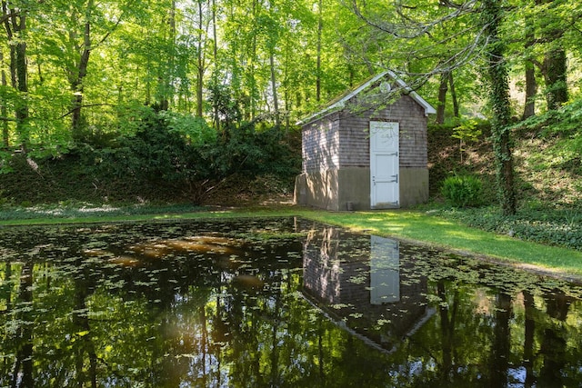 view of yard with a shed, an outbuilding, and a forest view