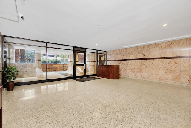 community lobby with a wall of windows, recessed lighting, and a security system
