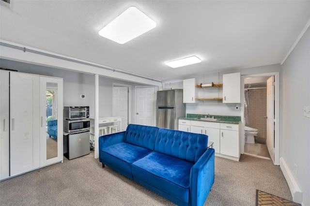 living area with light colored carpet and baseboards