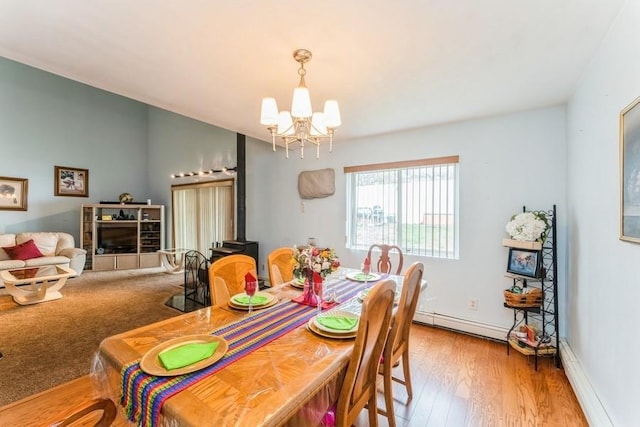 17 Bayview Ct, Inwood, NY 11096 - dining room with a chandelier, a wood stove, wood finished floors, baseboard heating, and baseboards