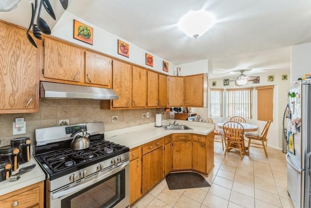 17 Bayview Ct, Inwood, NY 11096 - kitchen with under cabinet range hood, appliances with stainless steel finishes, light countertops, and a sink