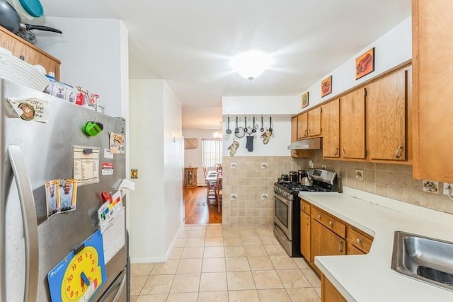 17 Bayview Ct, Inwood, NY 11096 - kitchen featuring stainless steel appliances, a sink, light countertops, under cabinet range hood, and light tile patterned flooring