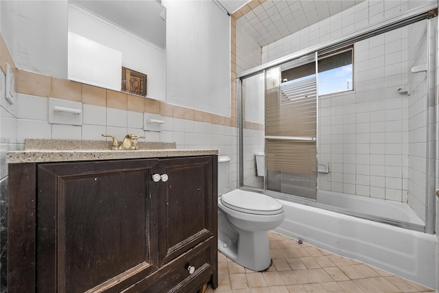 13 Barnett Rd E, Monroe, NY 10950 - bathroom featuring tile walls, toilet, tile patterned flooring, bath / shower combo with glass door, and vanity