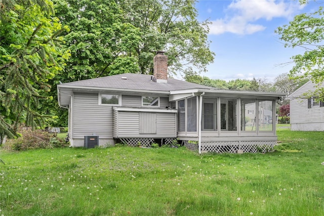 13 Barnett Rd E, Monroe, NY 10950 - back of property featuring a chimney, a sunroom, a lawn, cooling unit, and roof with shingles
