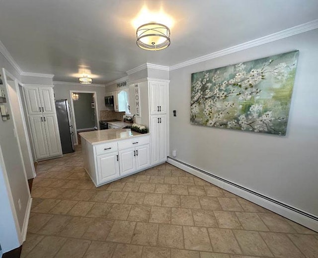 kitchen featuring baseboard heating, appliances with stainless steel finishes, a peninsula, white cabinetry, and baseboards