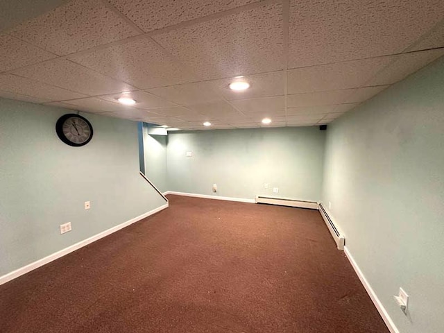 finished basement featuring carpet flooring, baseboards, a drop ceiling, a baseboard heating unit, and baseboard heating