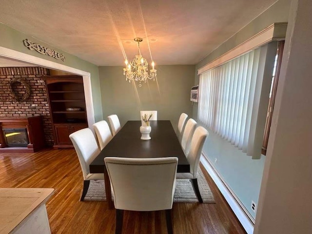 899 E Meadow Ave, North Bellmore, NY 11710 - dining area with a chandelier, a fireplace, wood finished floors, and a baseboard heating unit