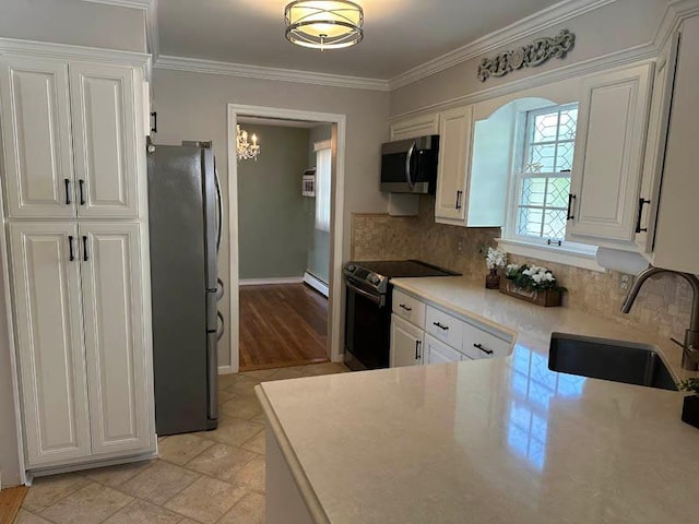 899 E Meadow Ave, North Bellmore, NY 11710 - kitchen featuring freestanding refrigerator, electric stove, stainless steel microwave, a sink, and baseboard heating