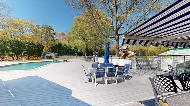 124 Montauk Hwy, Westhampton, NY 11977 - wooden deck with outdoor dining space, an outdoor pool, fence, a storage shed, and an outdoor structure