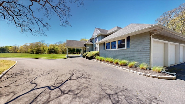124 Montauk Hwy, Westhampton, NY 11977 - view of property exterior featuring a lawn, a shingled roof, and a garage