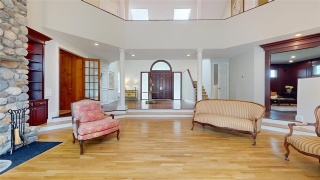 124 Montauk Hwy, Westhampton, NY 11977 - sitting room with decorative columns, light wood-type flooring, a towering ceiling, and recessed lighting