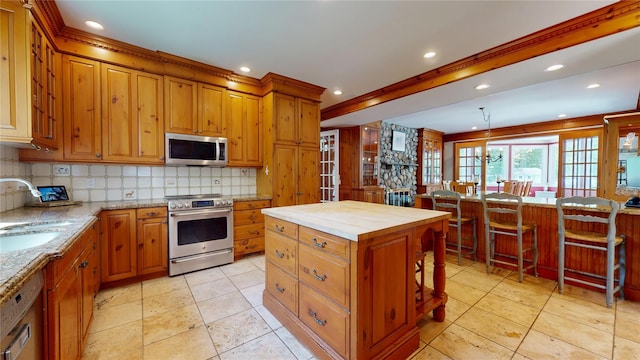 124 Montauk Hwy, Westhampton, NY 11977 - kitchen with stainless steel appliances, a sink, backsplash, brown cabinetry, and recessed lighting