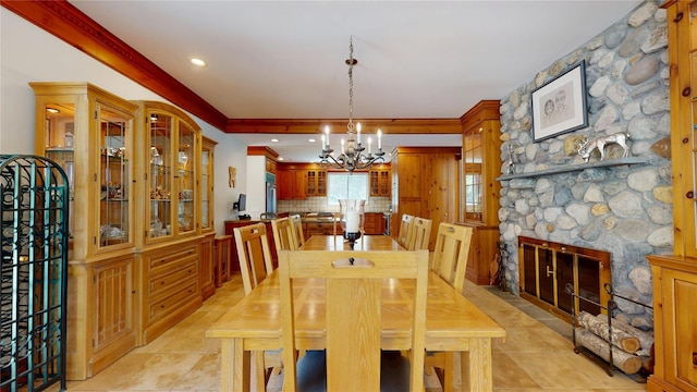 124 Montauk Hwy, Westhampton, NY 11977 - dining area featuring a chandelier, a stone fireplace, crown molding, and light tile patterned flooring