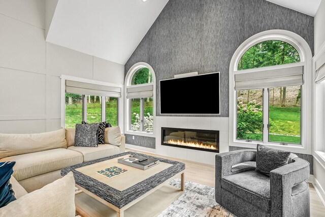 92 Random Farms Dr, Chappaqua, NY 10514 - living area featuring high vaulted ceiling, plenty of natural light, wood finished floors, and a tile fireplace