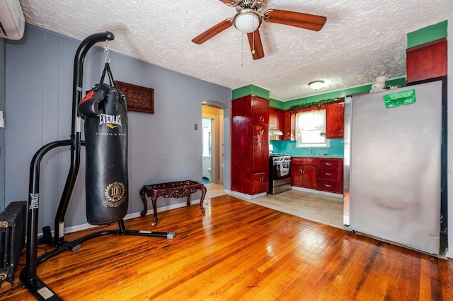 31 Thurman St, Yonkers, NY 10701 - kitchen with stainless steel appliances, a wall mounted AC, a ceiling fan, arched walkways, and a textured ceiling