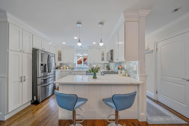 510 Fire Island Ave, Babylon, NY 11702 - kitchen with stainless steel appliances, wood finished floors, white cabinets, glass insert cabinets, and ornamental molding