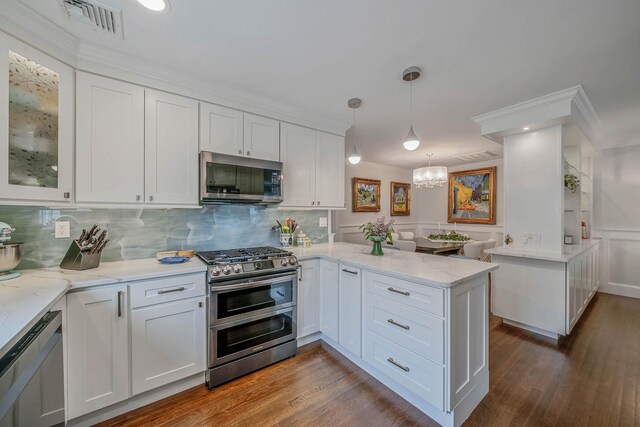 510 Fire Island Ave, Babylon, NY 11702 - kitchen featuring stainless steel appliances, a peninsula, crown molding, white cabinets, and decorative backsplash