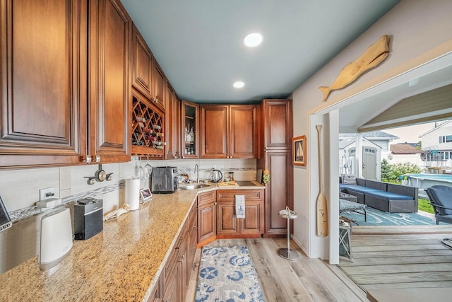 510 Fire Island Ave, Babylon, NY 11702 - kitchen with a sink, light wood-type flooring, light stone counters, recessed lighting, and brown cabinetry