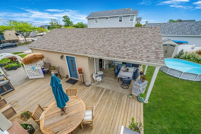 510 Fire Island Ave, Babylon, NY 11702 - wooden deck featuring an outdoor pool, an outdoor hangout area, a lawn, and outdoor dining space