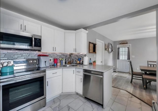 91 Valley Rd, Levittown, NY 11756 - kitchen featuring stainless steel appliances, a sink, light marble finish floors, and light countertops