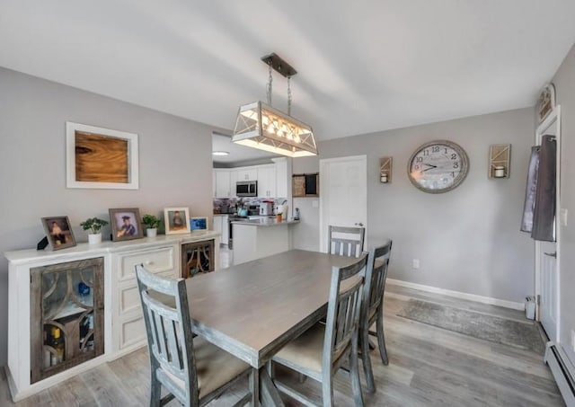 91 Valley Rd, Levittown, NY 11756 - dining room with light wood finished floors, a baseboard radiator, and baseboards