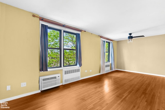 2015 Saint Paul Ave Unit 3H, Bronx, NY 10461 - empty room featuring radiator heating unit, a wall mounted air conditioner, wood finished floors, and baseboards