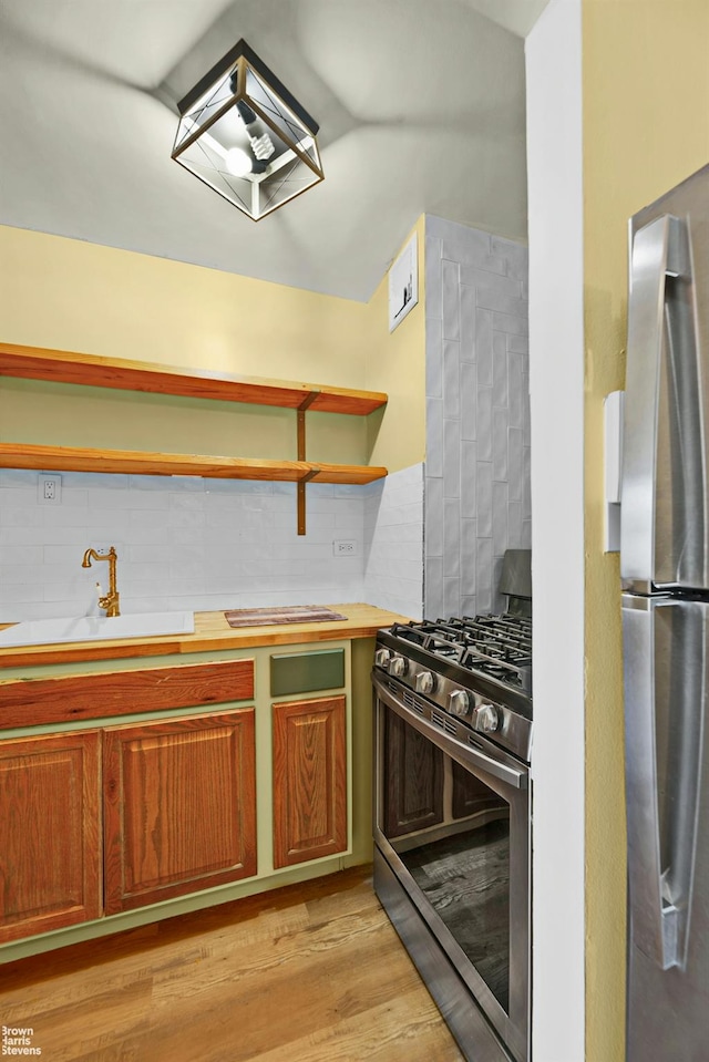 2015 Saint Paul Ave Unit 3H, Bronx, NY 10461 - kitchen featuring stainless steel appliances, open shelves, decorative backsplash, a sink, and light wood-style floors