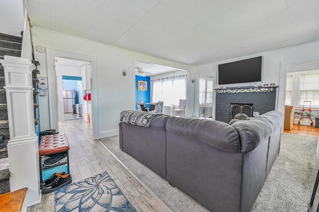 186-16 104th Ave, Saint Albans, NY 11412 - living room featuring light wood-style flooring, a fireplace, and a ceiling fan
