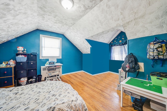 161 Grand Ave, Freeport, NY 11520 - bedroom featuring wood finished floors, multiple windows, baseboards, and vaulted ceiling