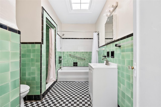 bathroom featuring tile walls, tile patterned floors, shower / bath combo, toilet, and vanity