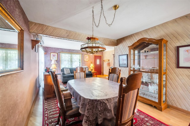 9 Forest Rd, Kings Park, NY 11754 - dining area with a chandelier, wooden walls, and wood finished floors