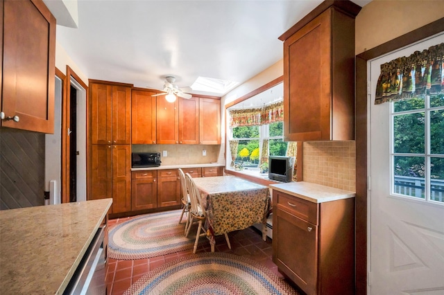 9 Forest Rd, Kings Park, NY 11754 - kitchen featuring black microwave, light countertops, tasteful backsplash, a skylight, and brown cabinetry
