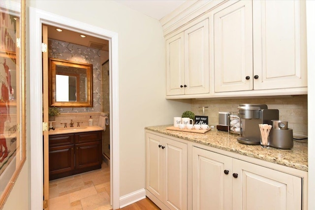 1515 Lowell Ave, New Hyde Park, NY 11040 - bar with backsplash, a sink, and light stone finish floors