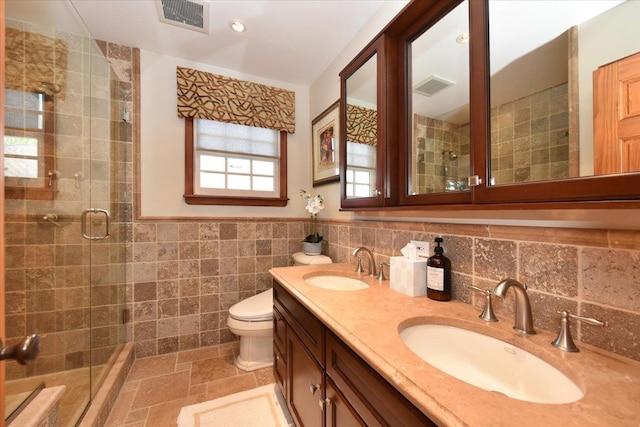 1515 Lowell Ave, New Hyde Park, NY 11040 - bathroom featuring a stall shower, tile walls, double vanity, toilet, and stone finish flooring
