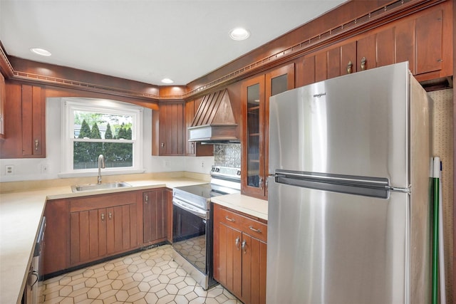 kitchen featuring stainless steel appliances, a sink, custom range hood, light countertops, and recessed lighting