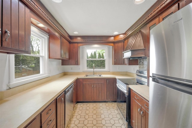 kitchen with stainless steel appliances, a sink, custom exhaust hood, healthy amount of natural light, and recessed lighting