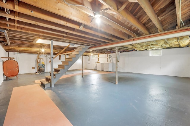 basement featuring oil tank, stairs, and separate washer and dryer