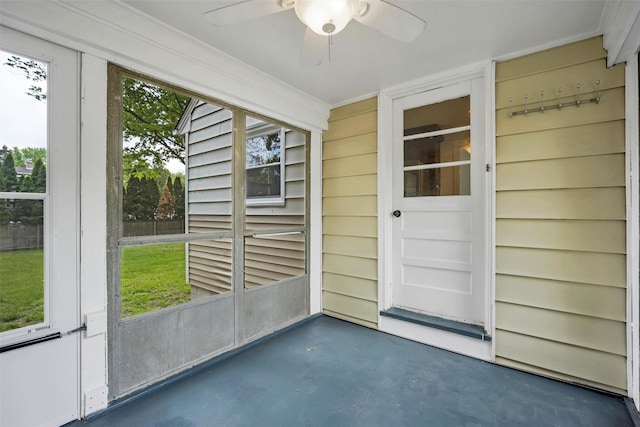 unfurnished sunroom with a ceiling fan and plenty of natural light