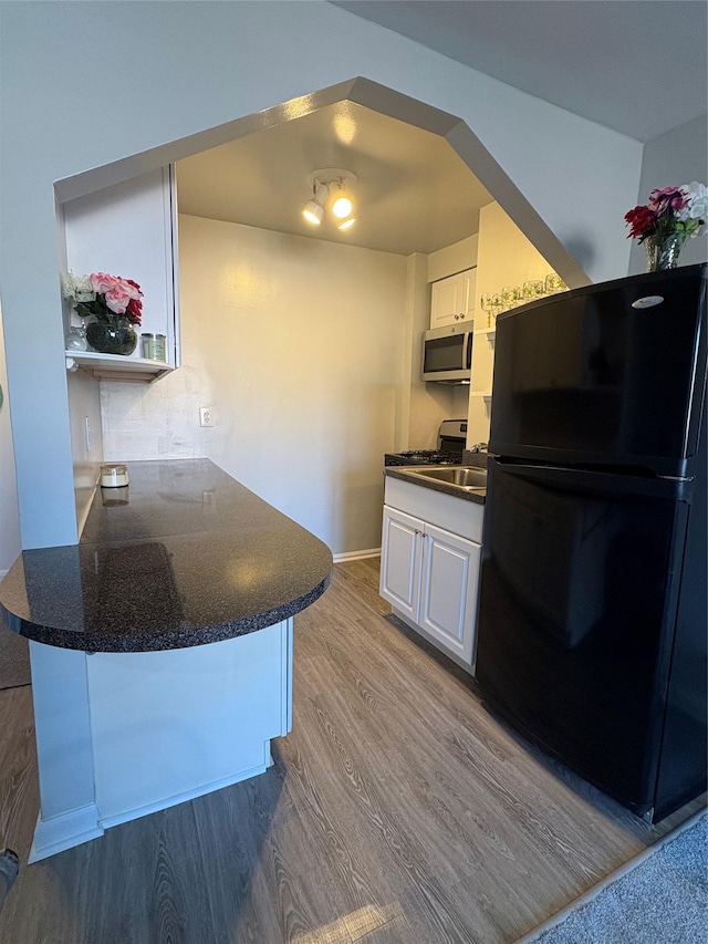 2107 Wallace Ave Unit 6E, Bronx, NY 10462 - kitchen with stainless steel appliances, a peninsula, dark countertops, and white cabinets